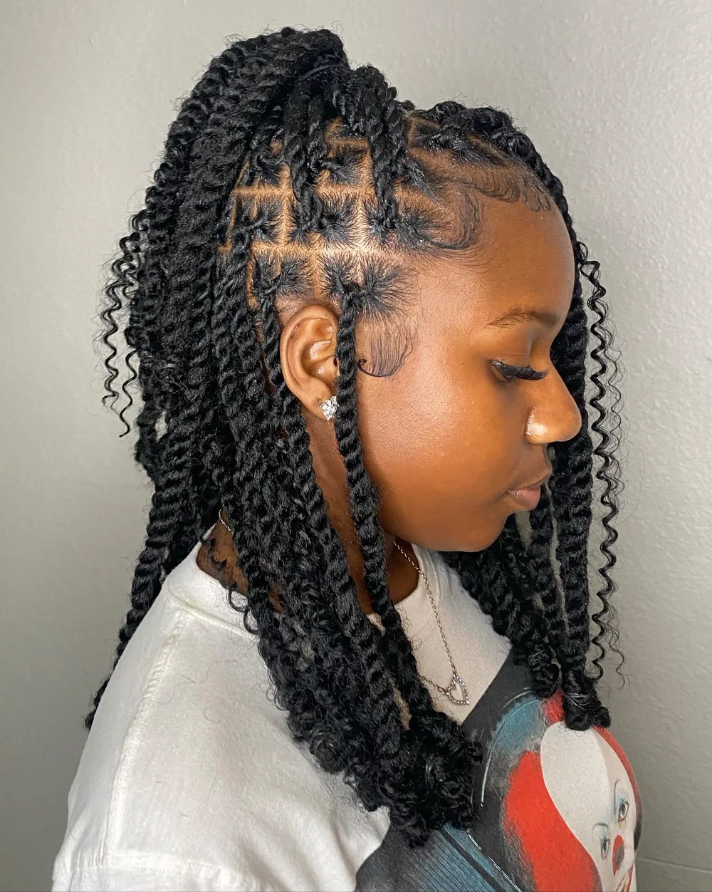 Coiffure half-up avec des tresses relevées sur le dessus