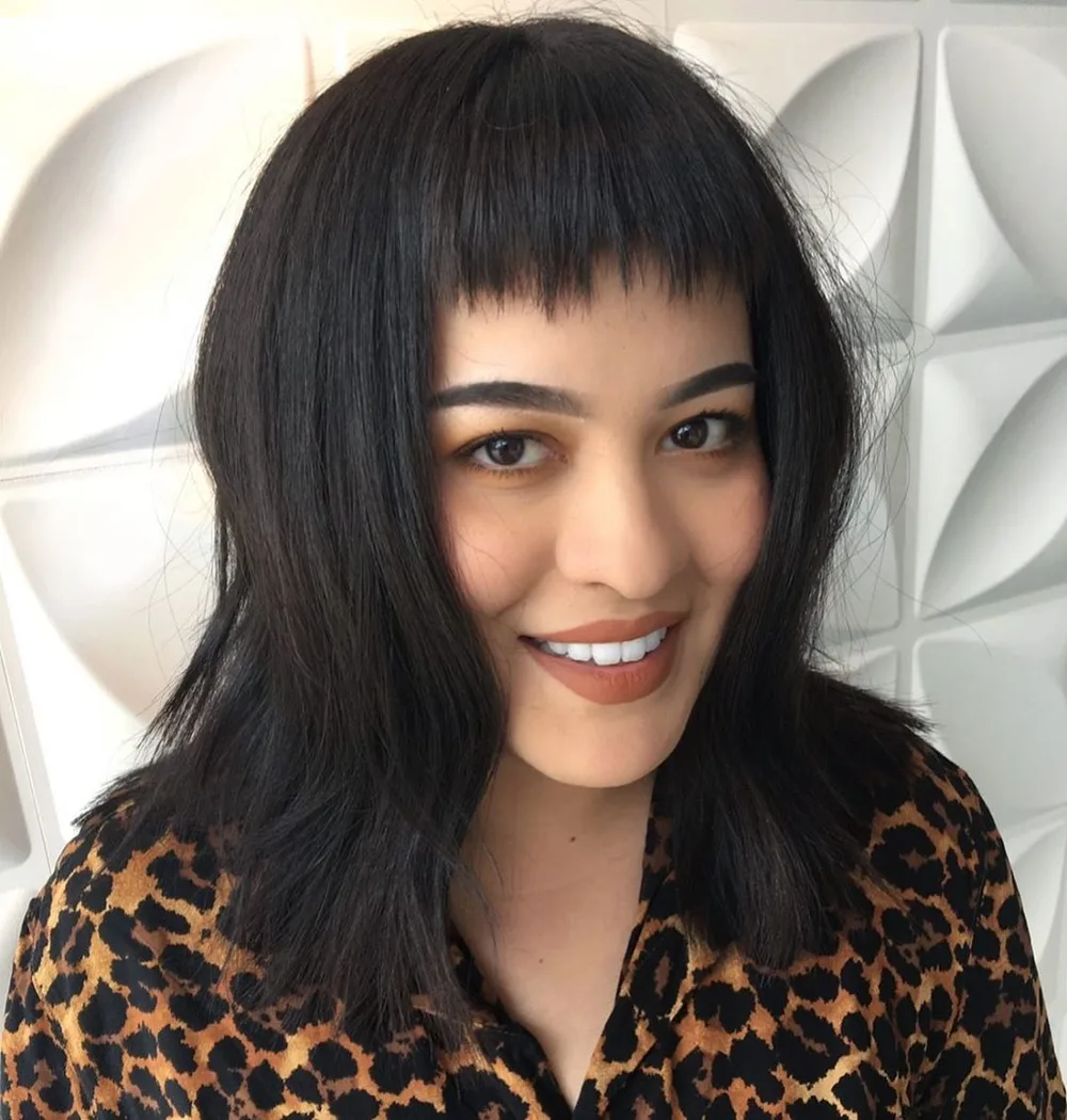 Coupe mi-longue avec baby bangs courtes et irrégulières