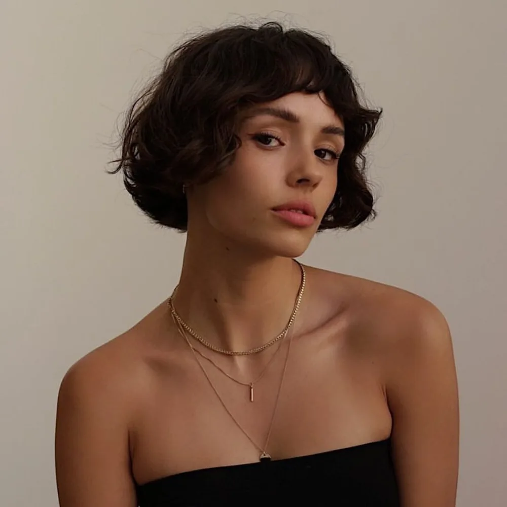 French bob court avec baby bangs sur cheveux ondulés
