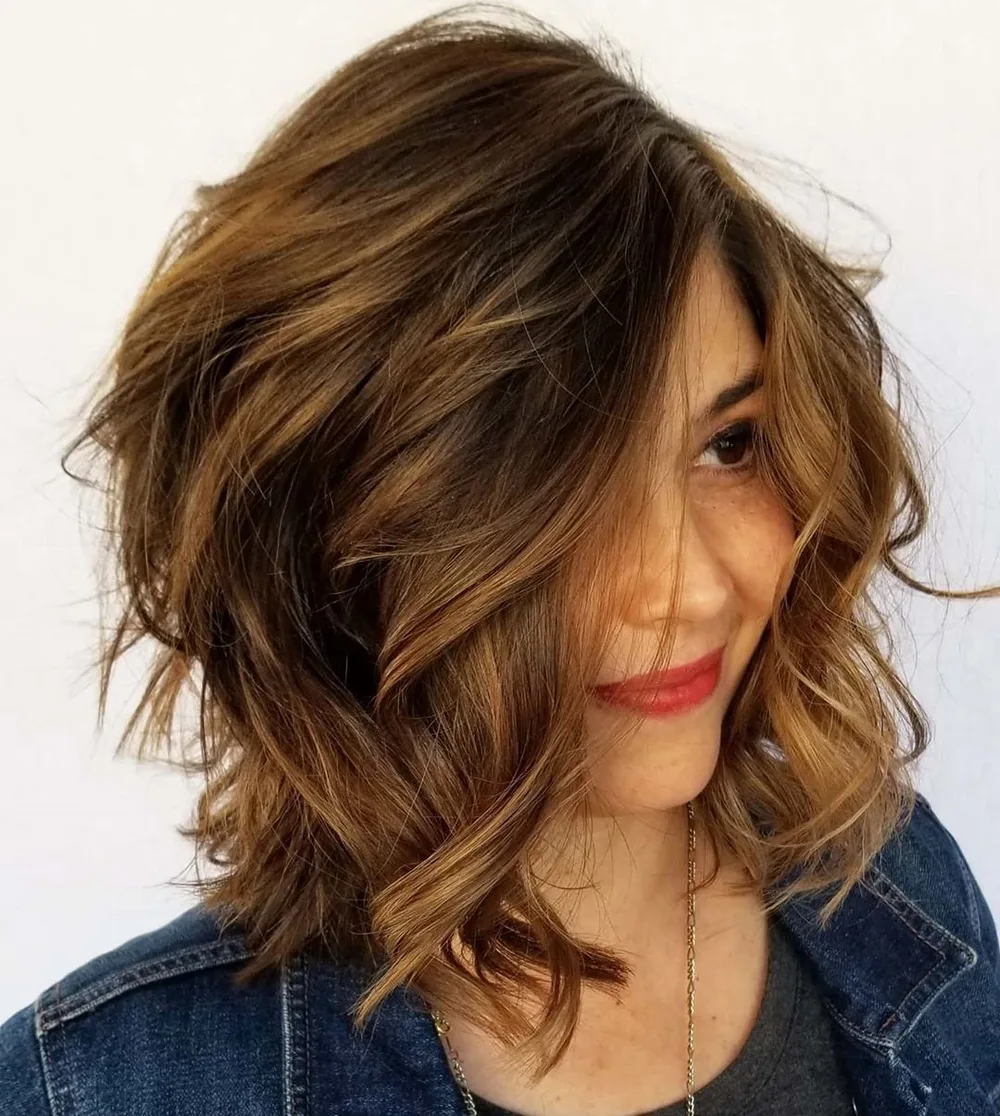 Lob wavy à raie profonde de côté et texture décoiffée sur cheveux épais