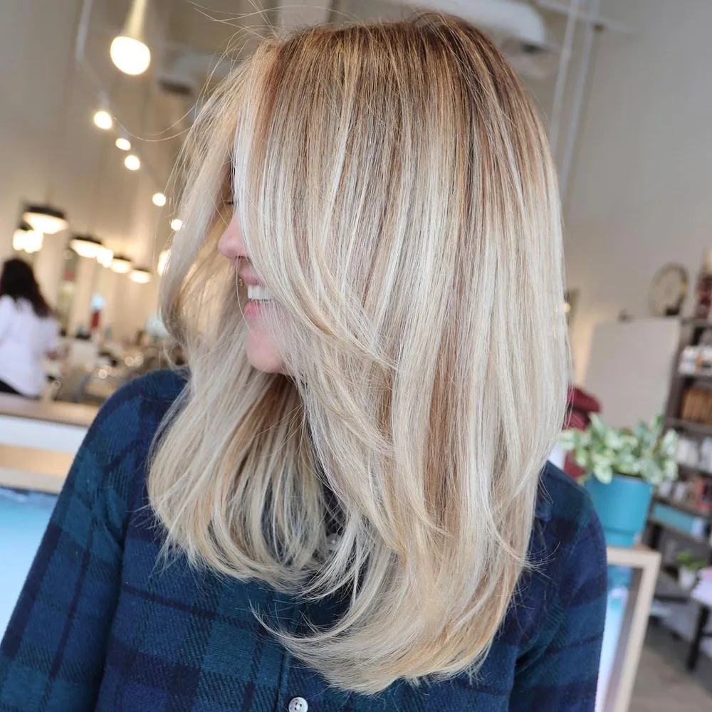 Longs cheveux avec couches swoopy, reflets blonds et shadow root