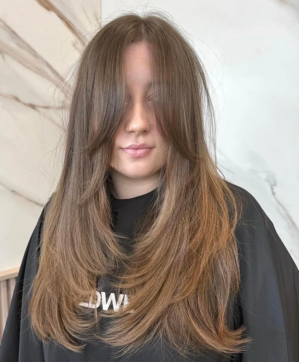 Longs cheveux avec une frange longue qui effleure les pommettes