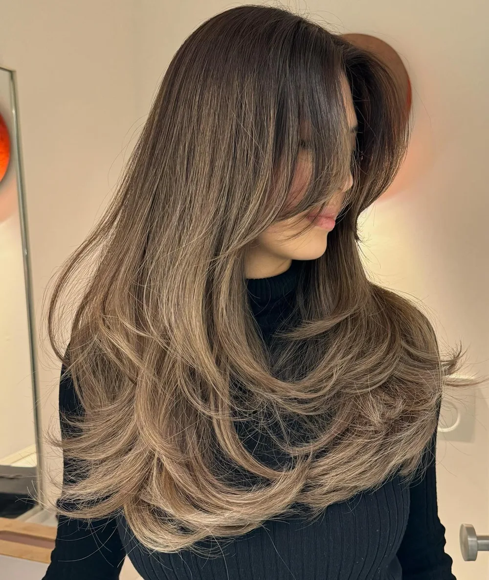 Longs cheveux lisses avec frange rideau et pointes effilées bouclées