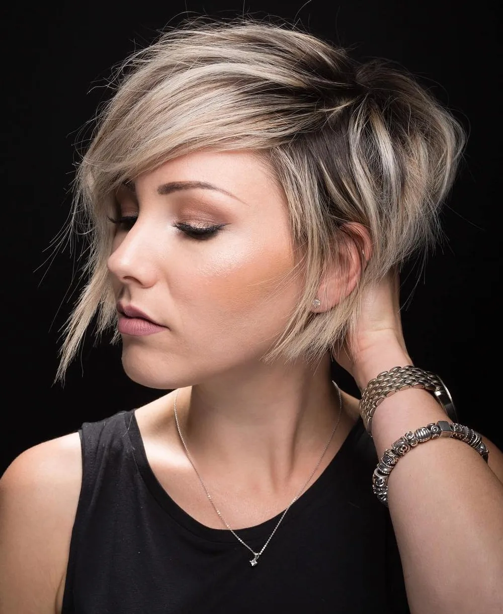 Pixie asymétrique blond avec mèche longue balayant le front et racines fondues