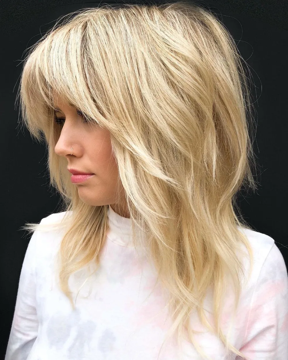 Shag blond volumineux et effilé avec frange fournie et couronne crêpée