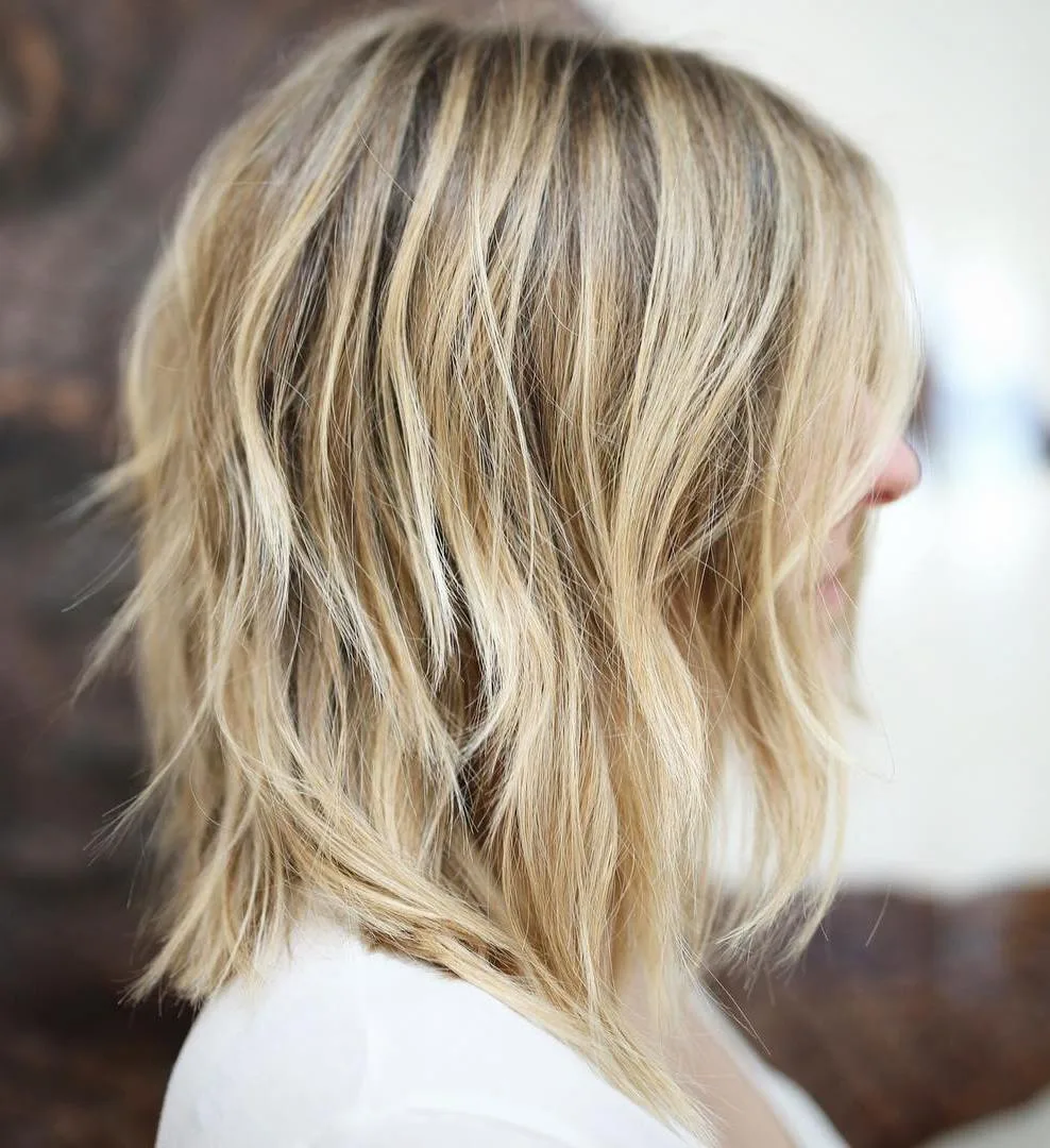 Shag mi-long blond façon années 70 avec couches plumeuses et volume