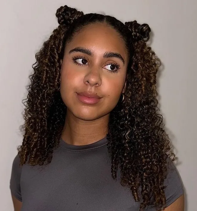 Space buns, deux macarons hauts sur cheveux bouclés