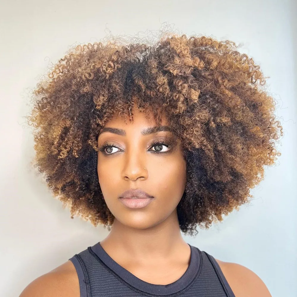Afro rond naturel avec balayage caramel sur base foncée, boucles définies