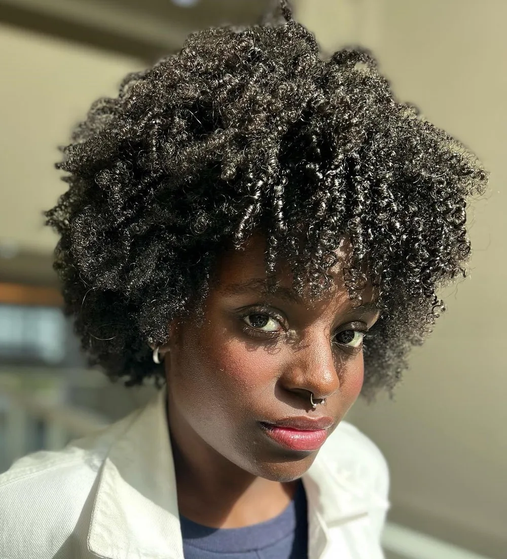 Afro texturé avec les boucles retombant sur le front en frange naturelle