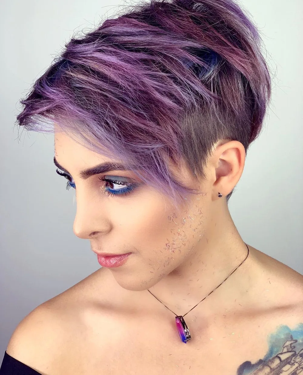 Balayage violet pastel à foncé sur pixie undercut, peau claire yeux bleus