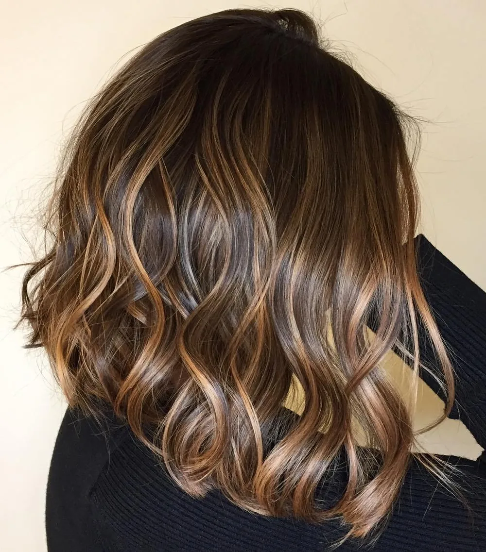 Base toffee brun foncé avec fins babylights dorés et vagues décoiffées