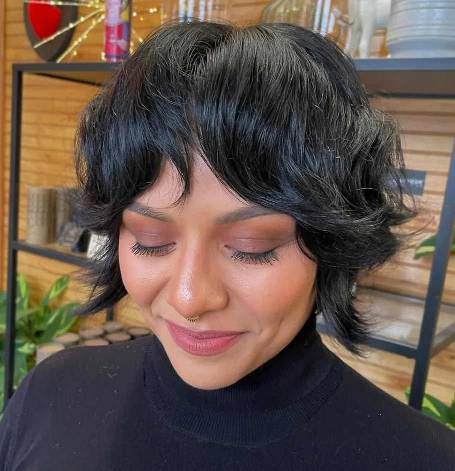 Bixie inspiré du wolf cut sur cheveux noirs ondulés avec frange