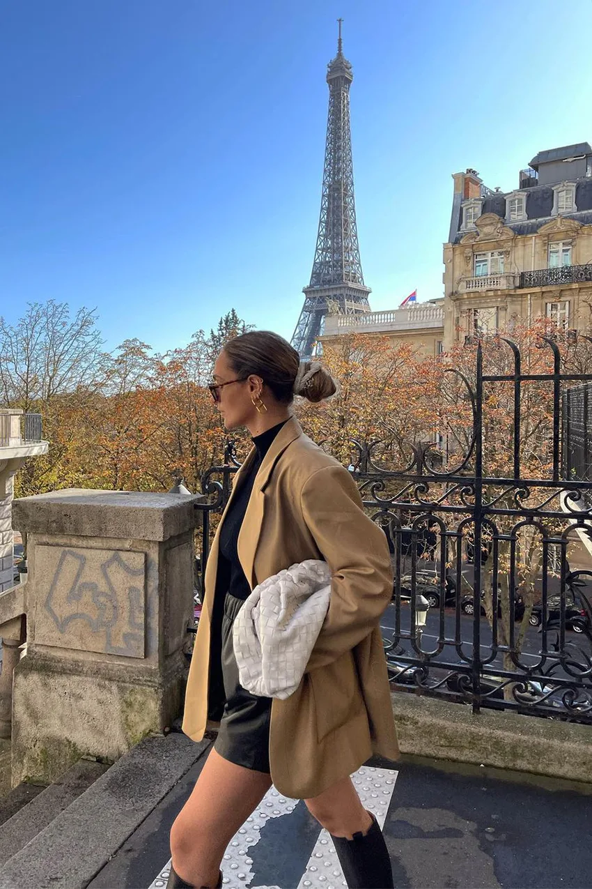 Blazer camel porté avec un col roulé noir et un short en cuir