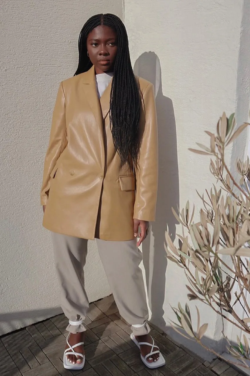 Blazer en cuir camel porté avec un tee-shirt et un jogging