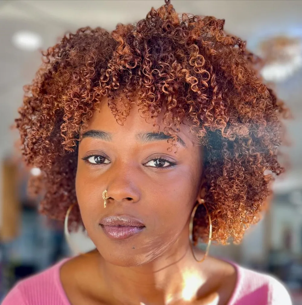Bob afro cuivré à balayage et frange bouclée sur cheveux naturels