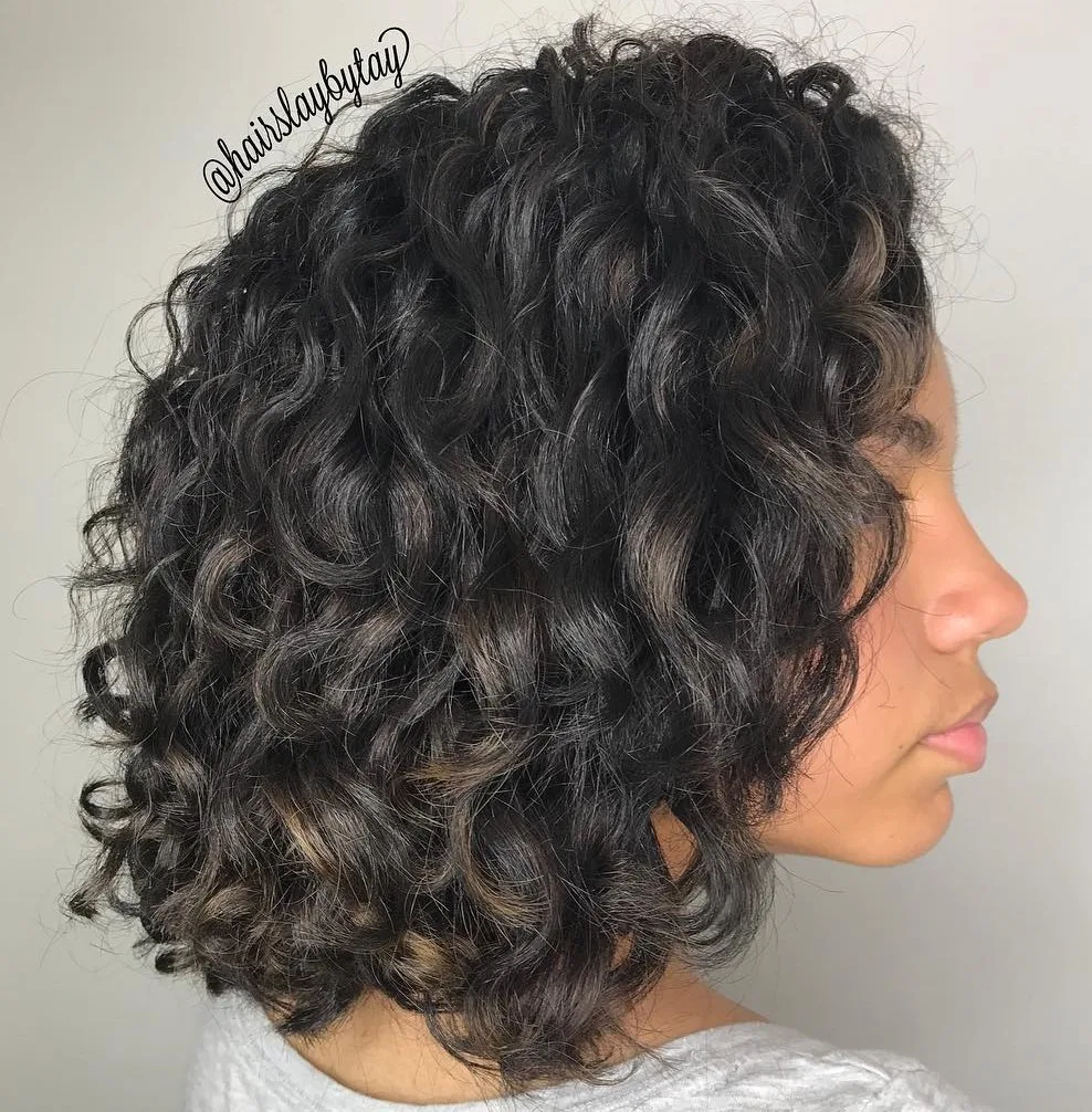 Bob bouclé noir avec discrets babylights, boucles rebondies