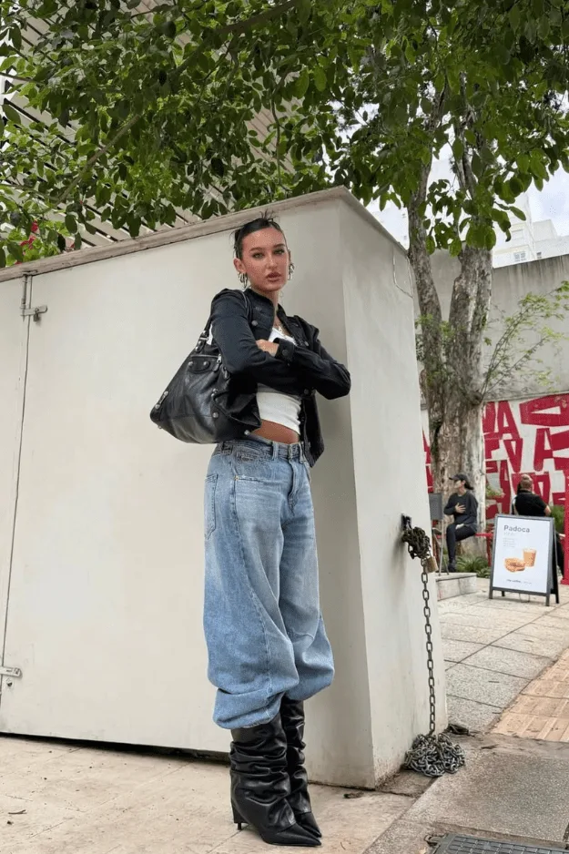 Bottes slouchy noires portées avec un jean large et un perfecto