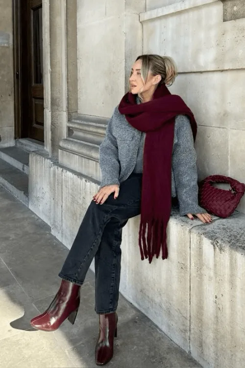 Bottines bordeaux effet croco portées avec un jean droit et une écharpe rouge
