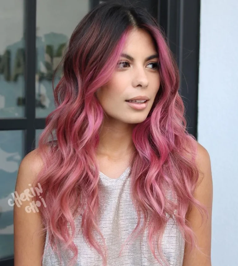 Brune avec mèches magenta vives encadrant le visage sur longues vagues