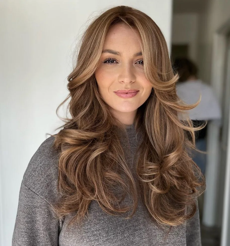 Butterfly cut brun clair avec raie au milieu et longueurs flippées vers l'extérieur