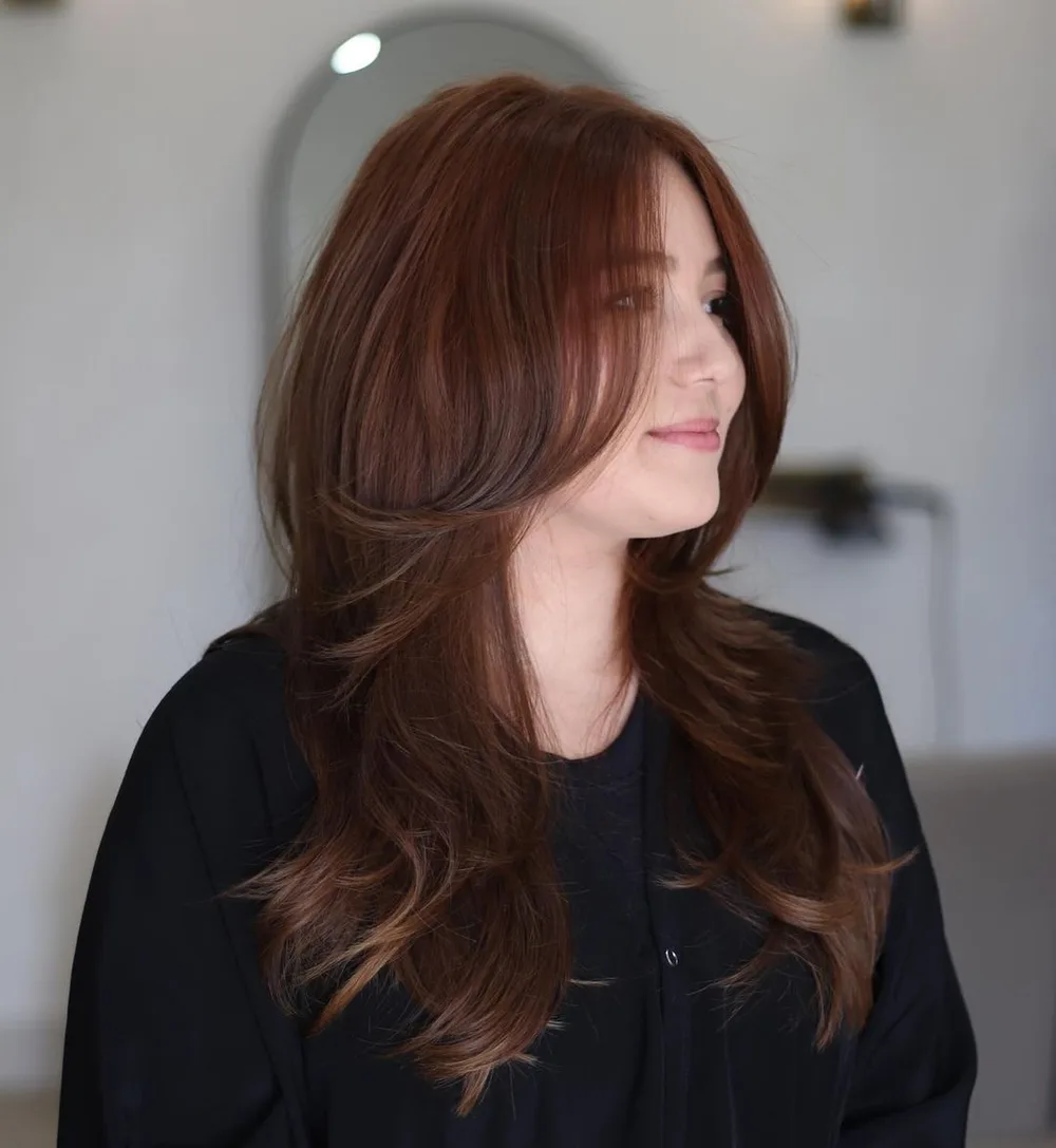 Butterfly cut façon shag avec frange et couches encadrantes sur cheveux auburn