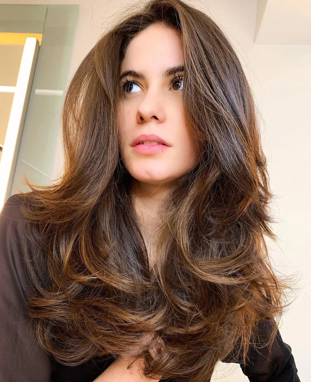 Butterfly cut sur cheveux longs chocolat avec couches bouclées et volume généreux