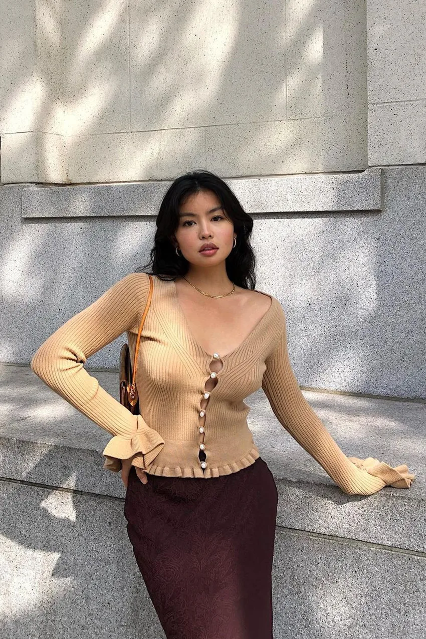 Cardigan camel boutonné porté avec une jupe lingerie bordeaux