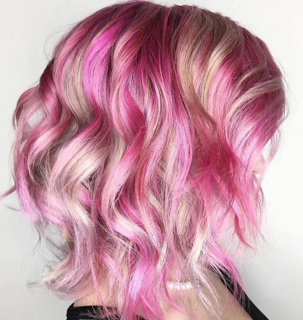 Carré blond avec larges mèches framboise et boucles