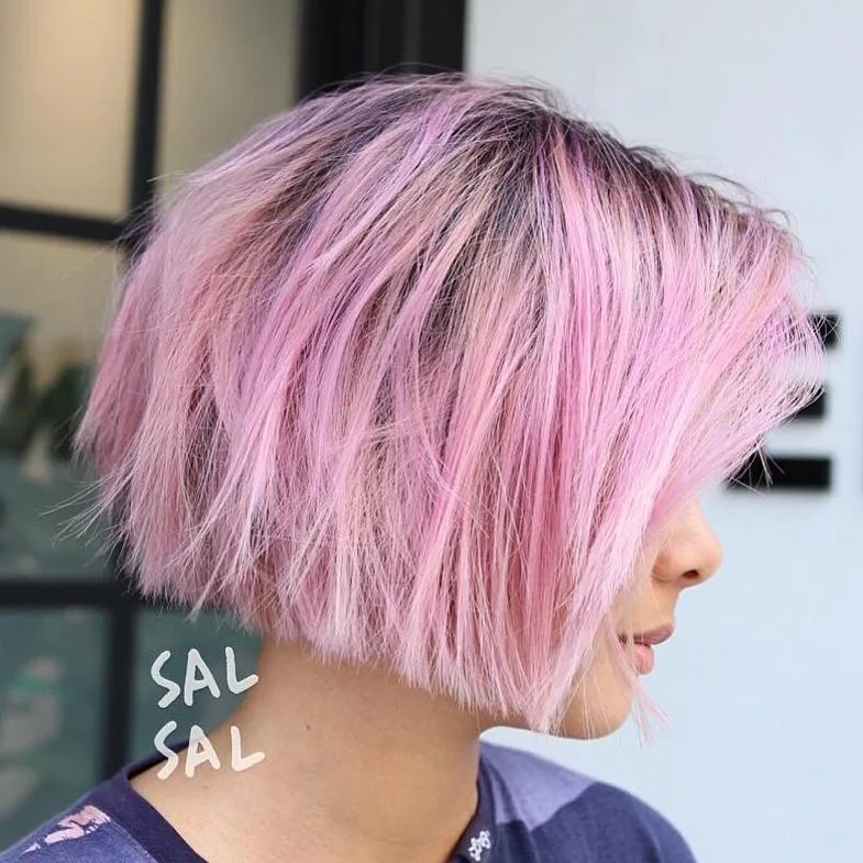 Carré blond avec mèches magenta et pastel, racines plus foncées, cheveux trempés de rose