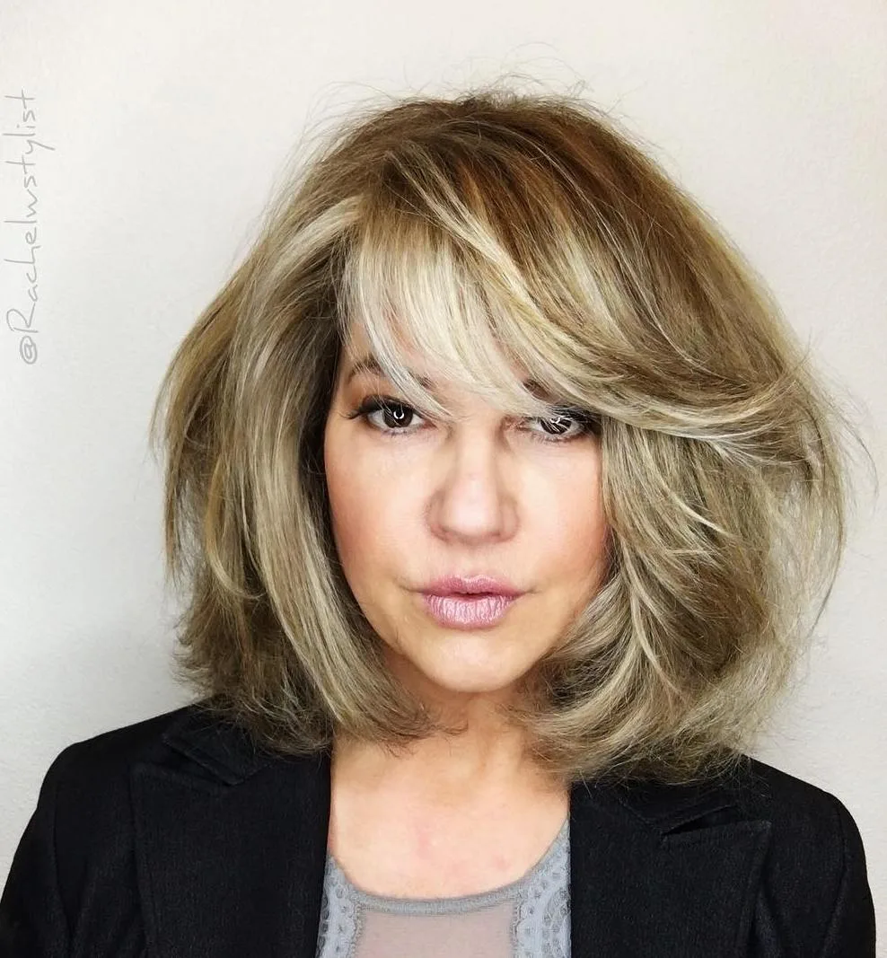 Carré blond volumineux blowout avec frange adoucissant le visage