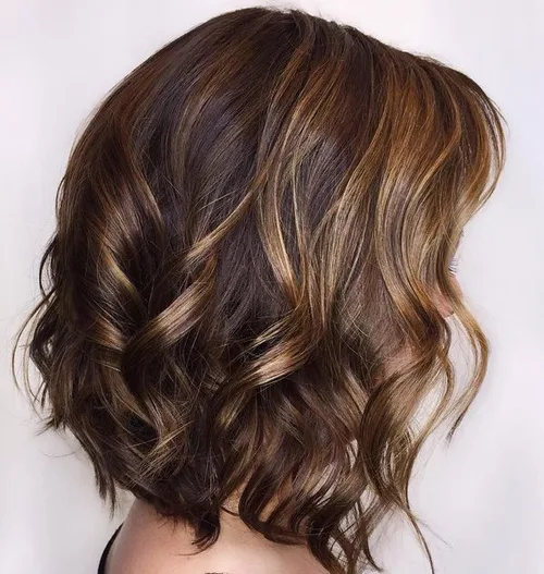 Carré bouclé avec faux-balayage caramel suivant le mouvement des boucles