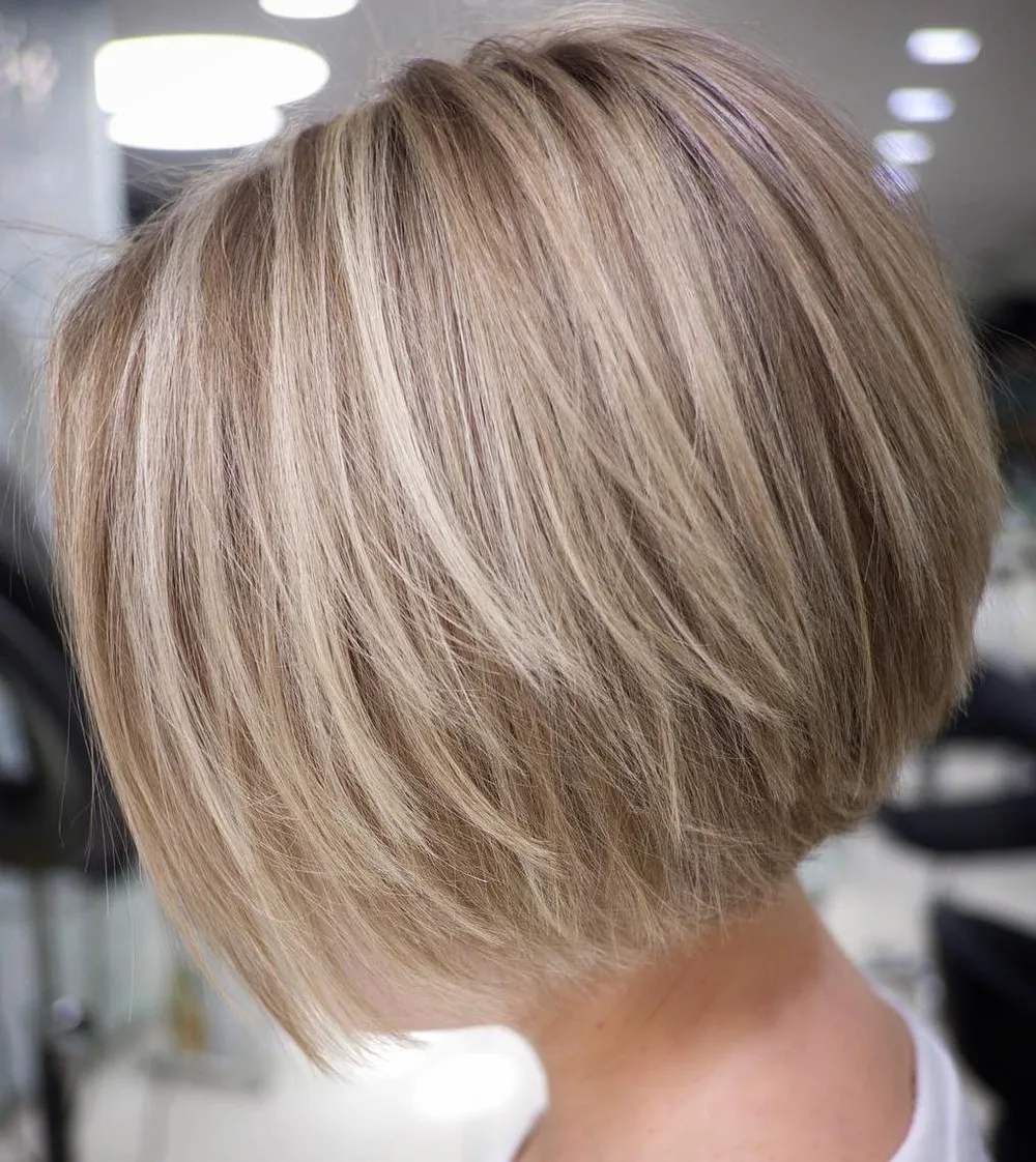 Carré court au menton coiffé en blowout arrondi avec balayage blond