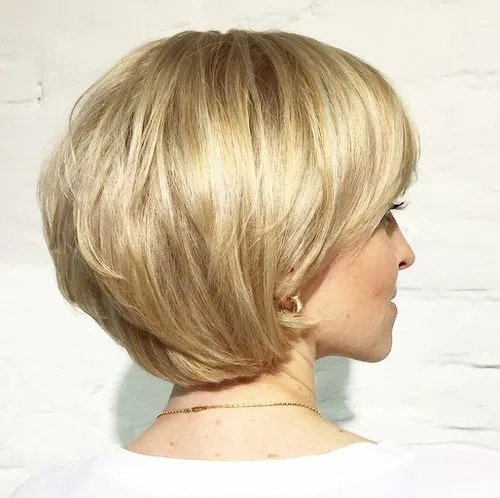 Carré court blond doré aux couches arrondies et volume bombé