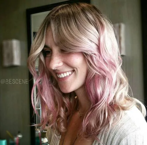 Cheveux blond beige avec accents rose blush très subtils et ondulations