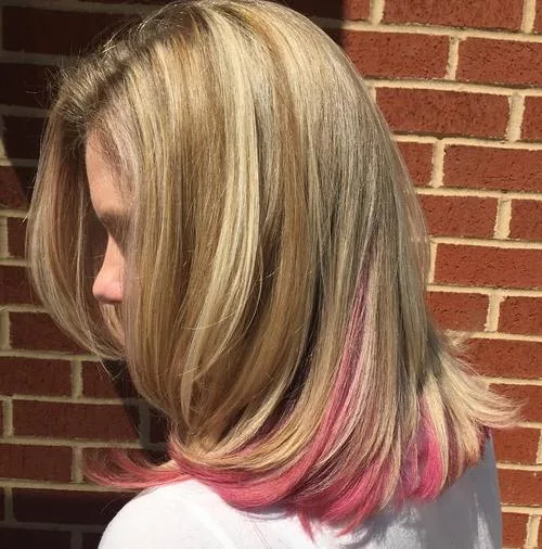 Cheveux blonds avec pointes rose pastel en peekaboo, mèches cachées