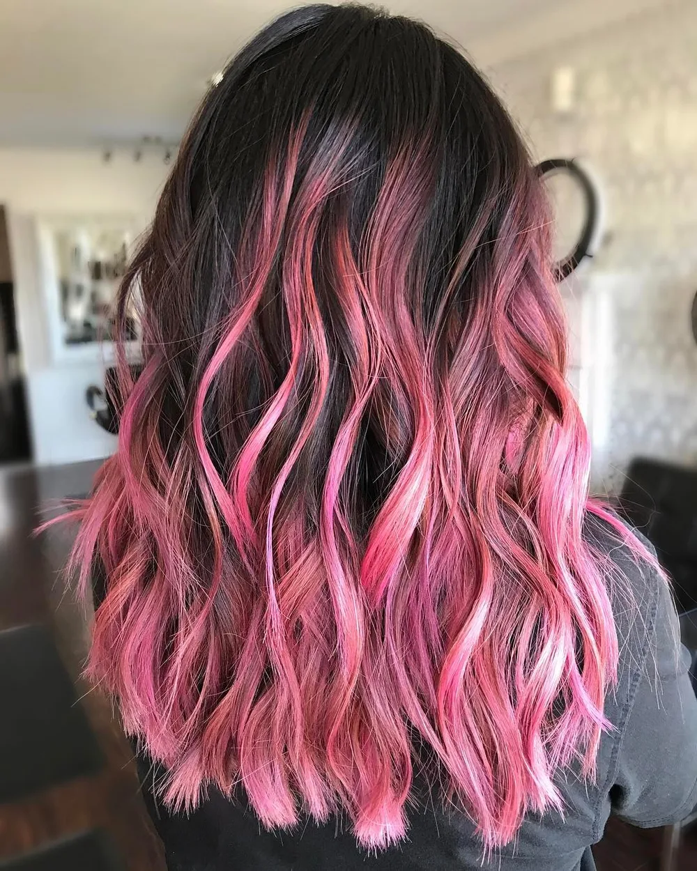 Cheveux brun foncé avec balayage rose cerise intense sur vagues