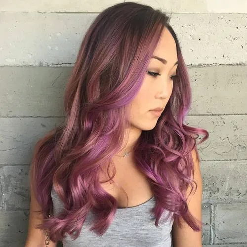 Cheveux bruns avec balayage lavande et rose pastel sur longues vagues