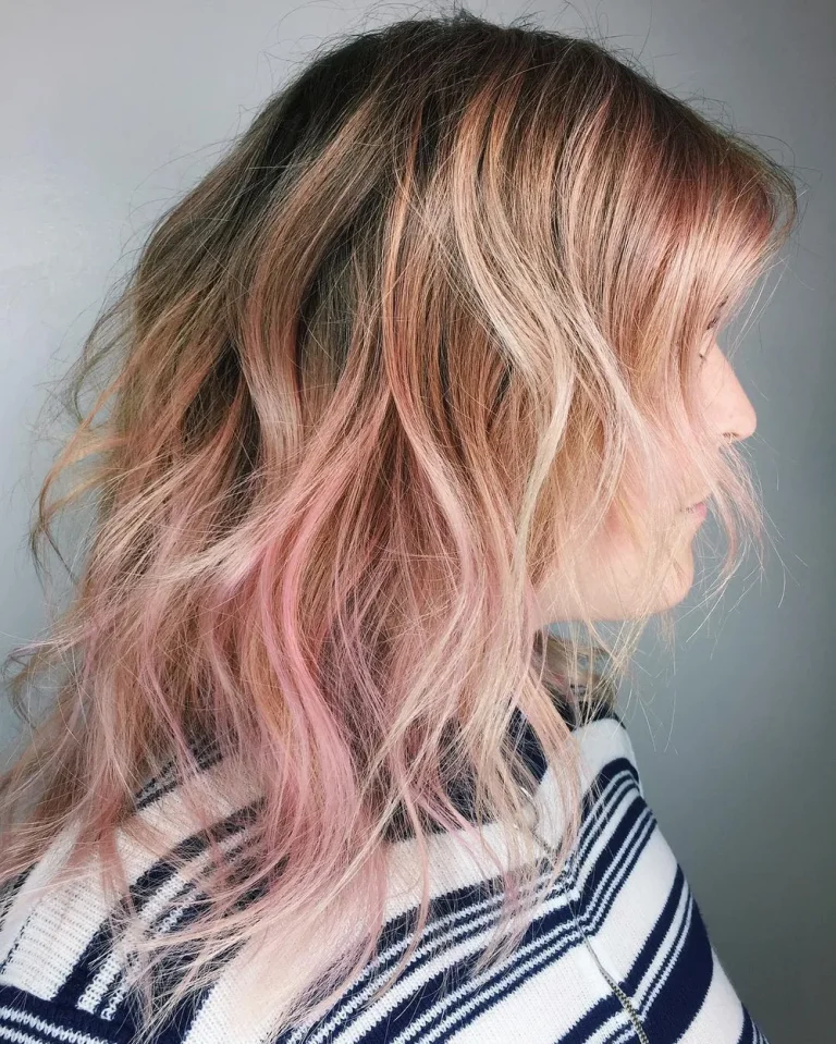 Cheveux rose gold en dégradé sur peau claire, longueurs ondulées