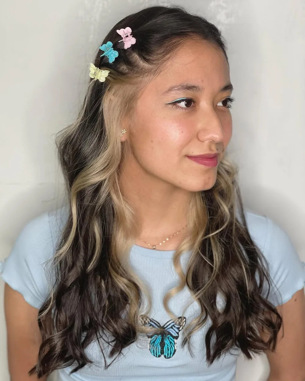 Coiffure early 2000s avec plusieurs petites barrettes papillon colorées