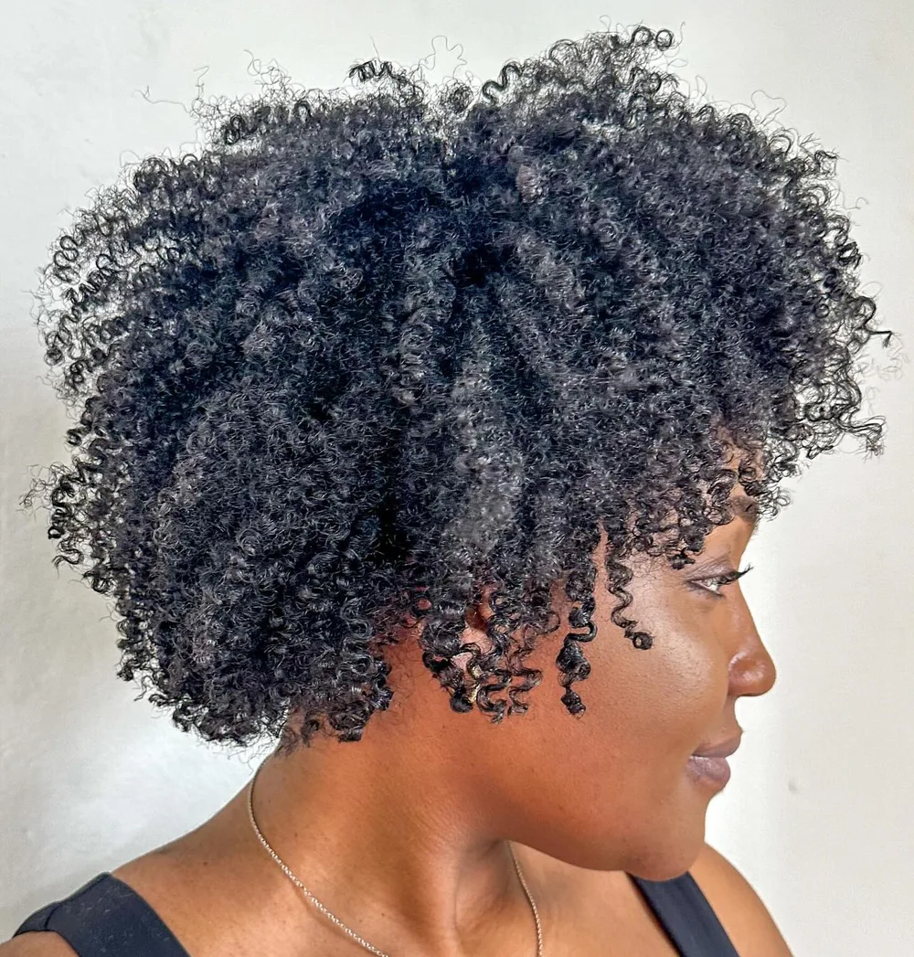 Coiffure kinky afro volumineuse aux boucles souples rassemblées, cheveux naturels