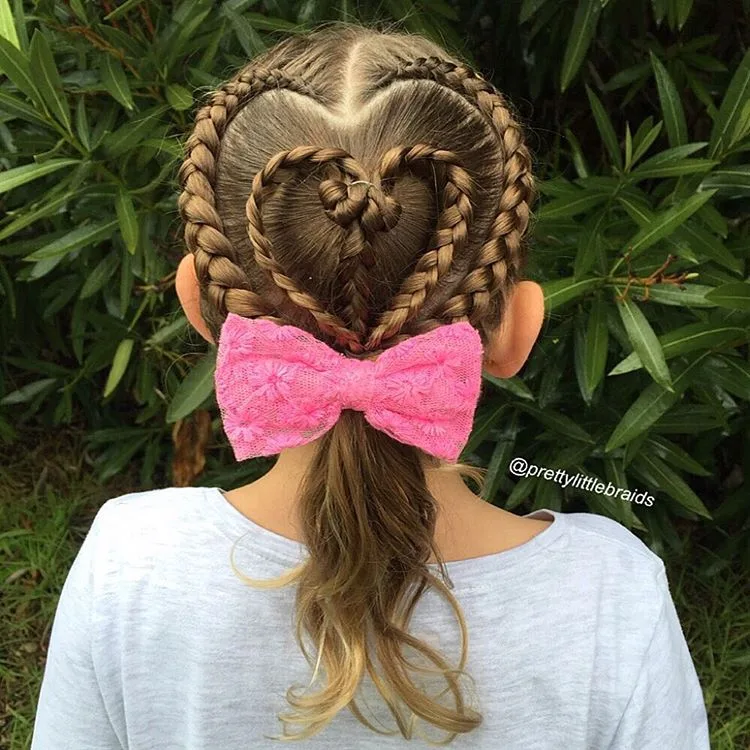 Coiffure petite fille avec tresses françaises en forme de cœur et gros nœud