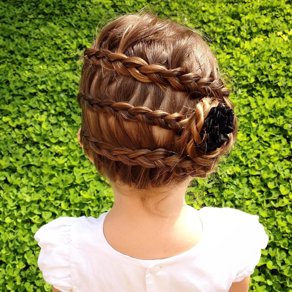 Coiffure petite fille avec trois tresses réunies en rosette plate et barrette