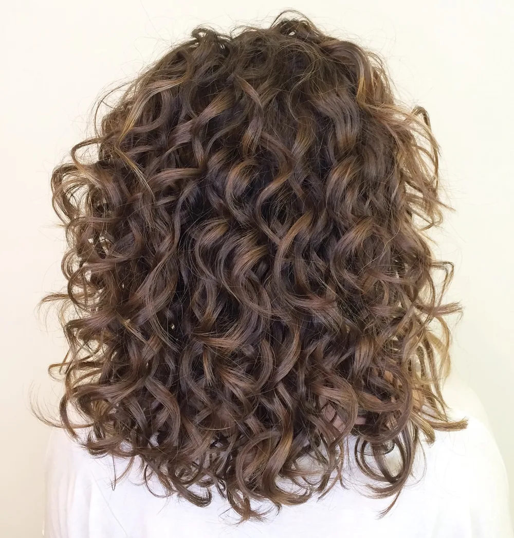 Coupe aux épaules avec boucles rebondies et volumineuses