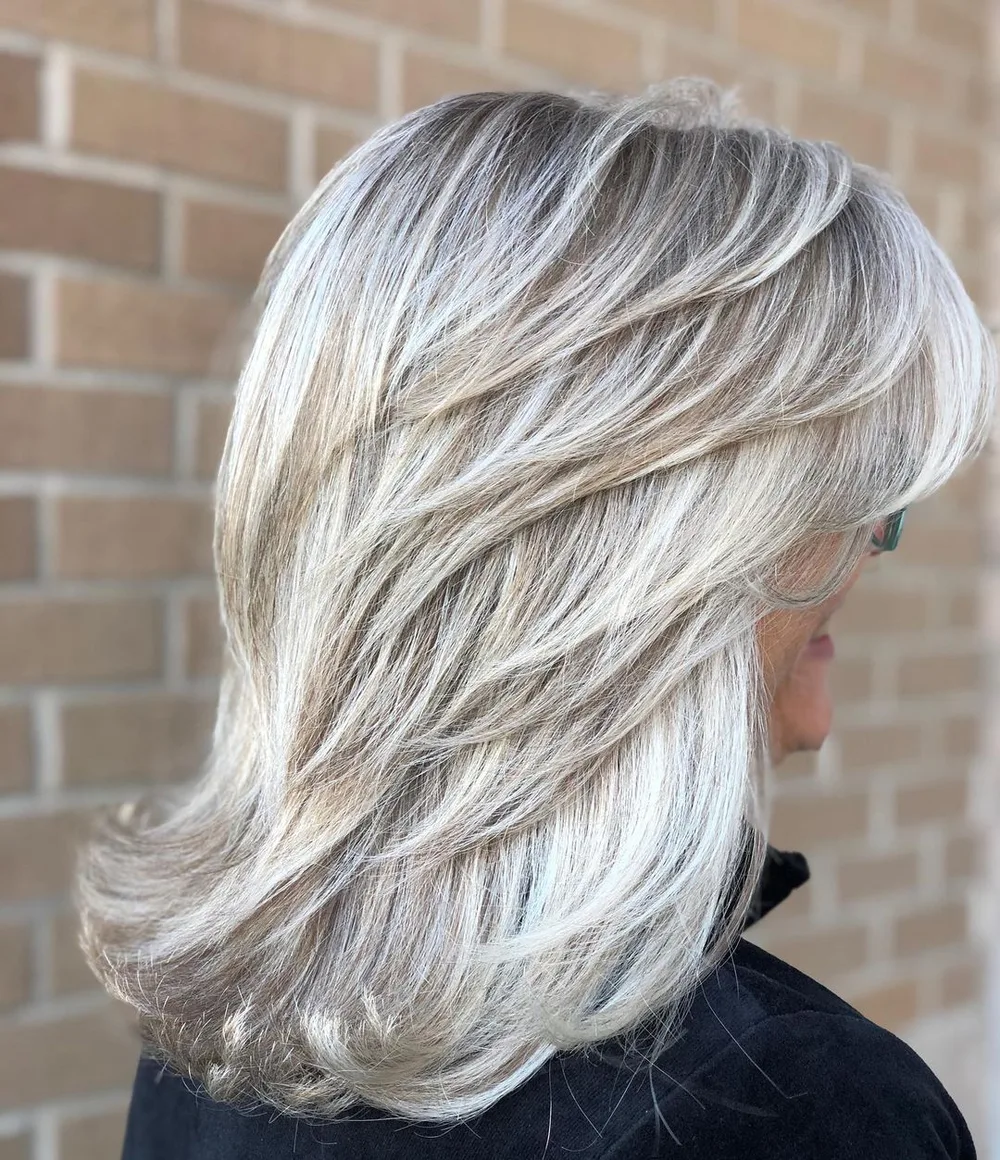 Coupe mi-longue plumeuse blanc argenté aux reflets glacés