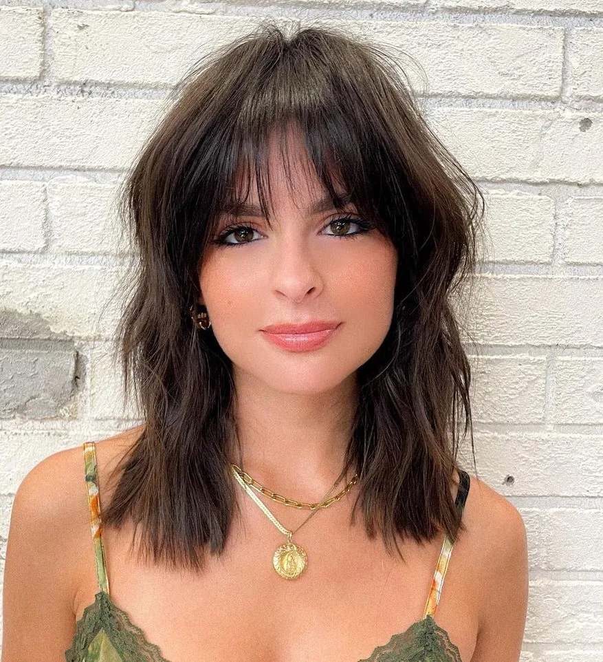 Coupe mi-longue texturisée brune avec frange, visage rond