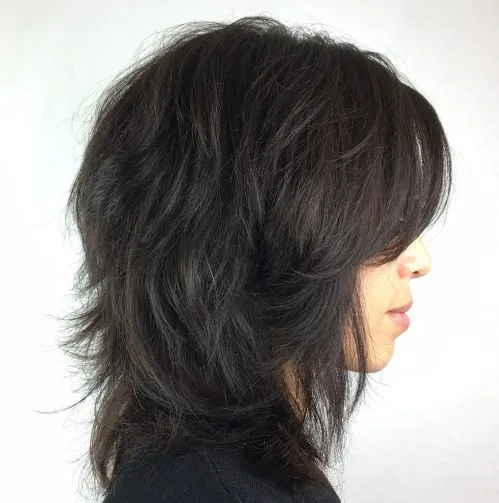 Coupe shag mi-longue brun foncé avec frange et couches wispy vaporeuses
