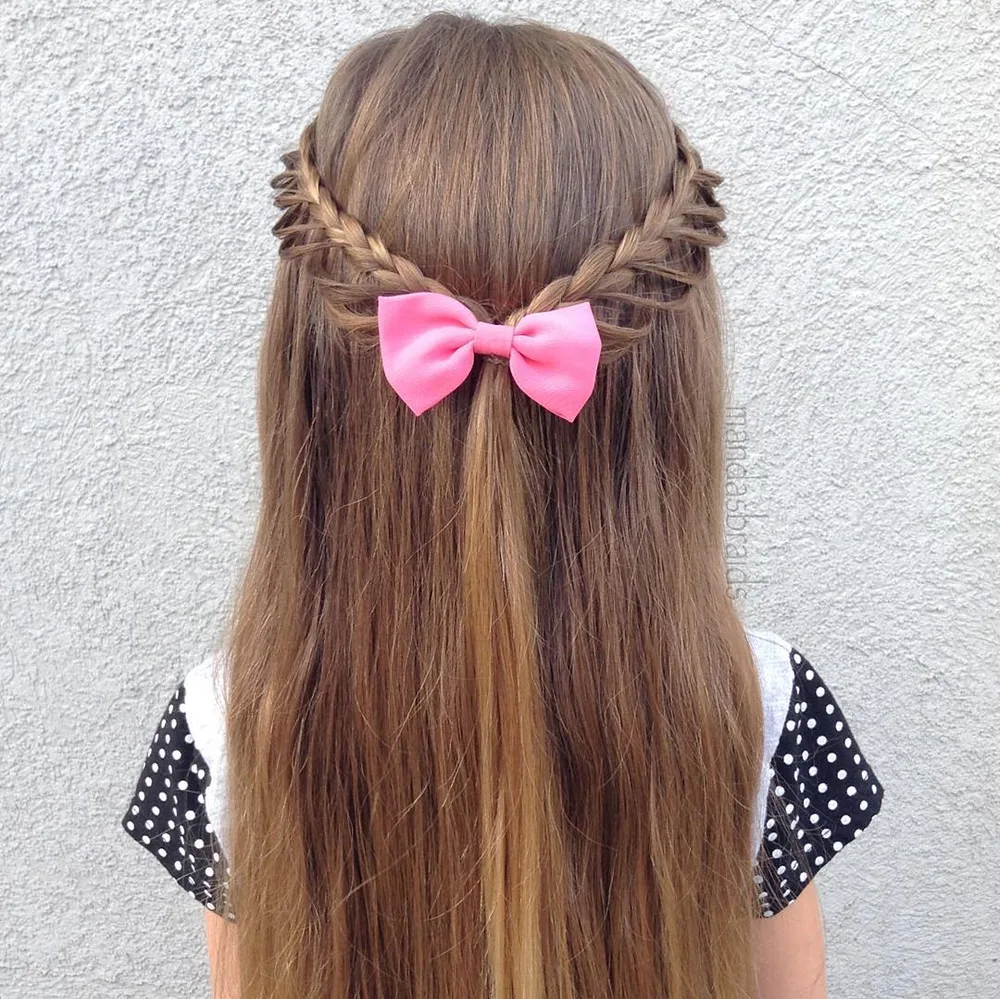 Demi-attache petite fille avec tresses en boucles et gros nœud rose