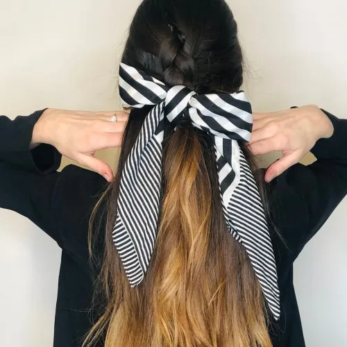 Demi-queue tressée agrémentée d'un foulard rayé noué, coiffure bohème