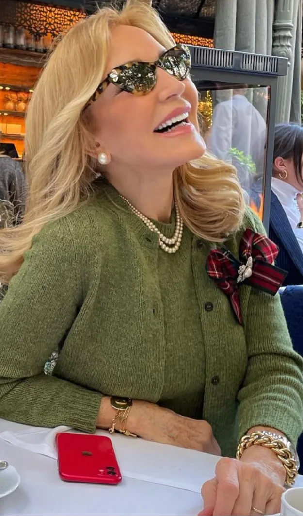 Femme de plus de 50 ans en maille verte avec bijoux dorés statement et perles, style automne