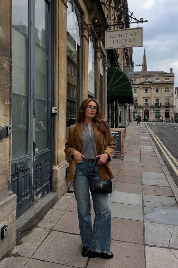 Femme en veste en suède caramel avec jean large et sac porté épaule